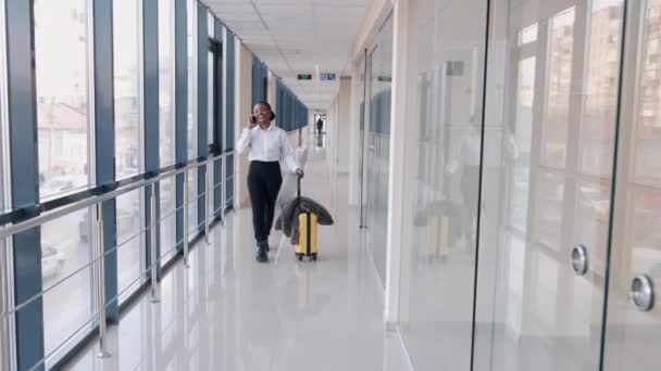 African-American woman is waiting with baggage at the airport — Stock Video