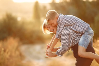 Anne ve küçük oğlu bahar tarlasında yürüyorlar.