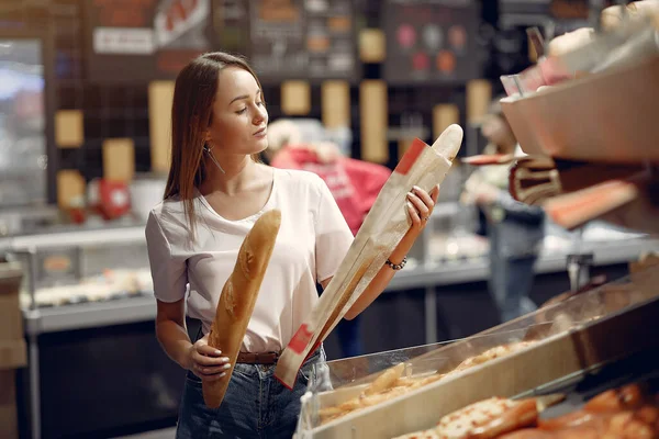 Junge Frau kauft im Supermarkt ein — Stockfoto