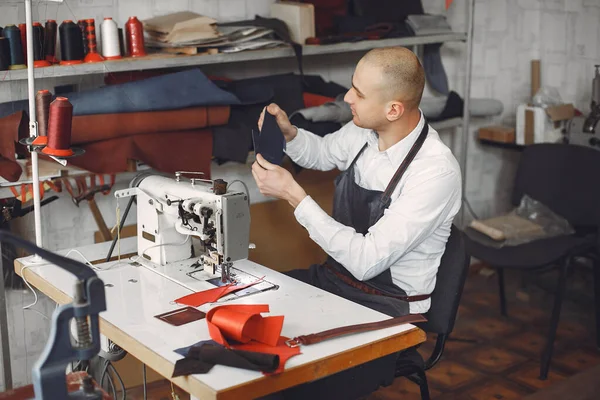 Man in a studio creates leather ware