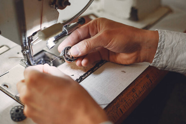 Man in a studio creates leather ware