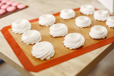 Üniformalı şekerci pastaları süslüyor.