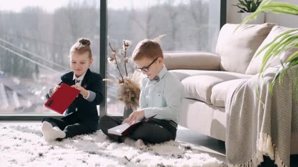 Kinder schreiben im Wohnzimmer in ihre Notizbücher — Stockvideo