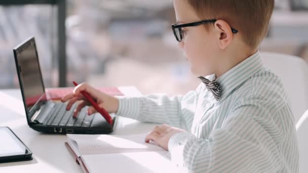 Ученик начальной школы учится с ноутбуком — стоковое видео