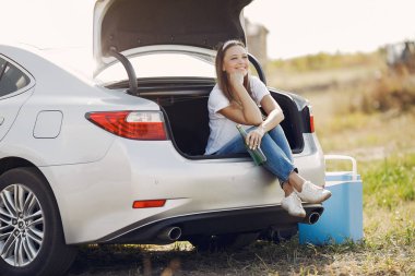 Bagajda suyla oturan zarif bir kadın.