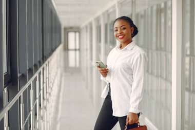 Ofiste dizüstü bilgisayarı olan siyahi bir kadın.