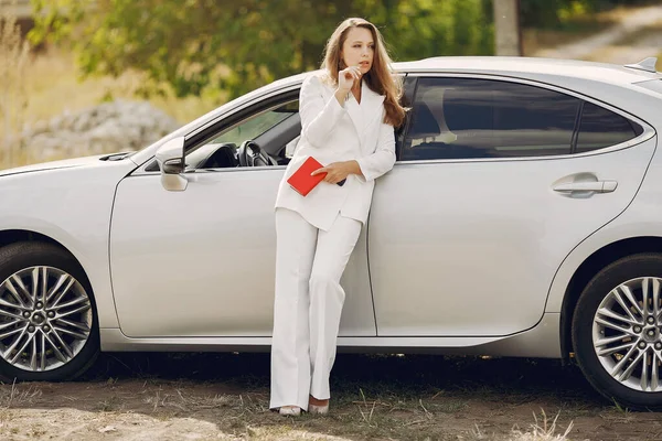 Элегантная женщина, стоящая у машины — стоковое фото