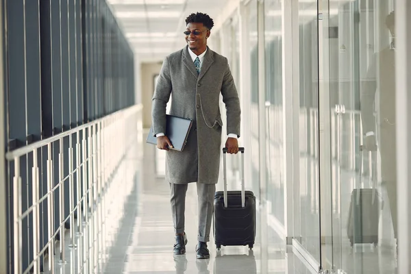 Elegant black man at the airport with a suitcase — Stock Photo, Image