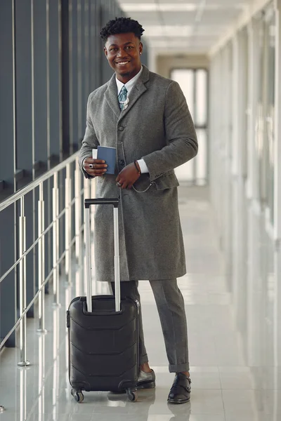 Elegant black man at the airport with a suitcase — Stock Photo, Image