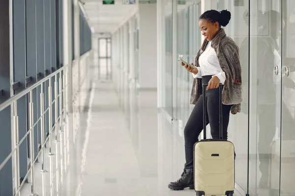 Schwarze Frau mit Koffer am Flughafen — Stockfoto