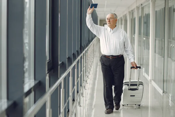 Eleganter alter Mann mit Koffer am Flughafen — Stockfoto