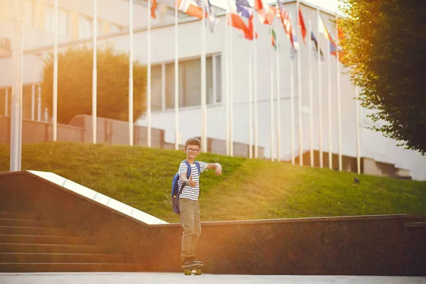 Colegial con un patín y una mochila — Foto de Stock