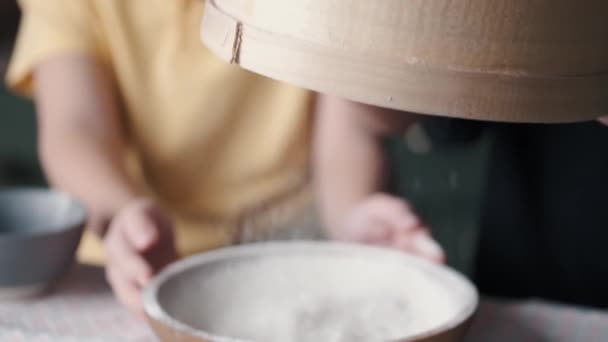 I bambini stanno setacciando la farina in una ciotola insieme in una cucina moderna — Video Stock