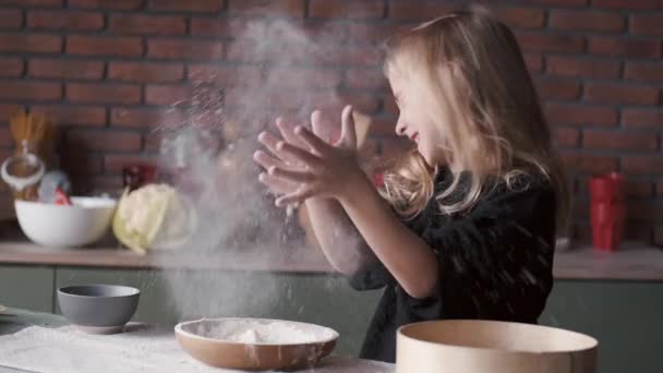 Νεαρό κορίτσι χειροκροτεί στο αλεύρι σε μια κουζίνα — Αρχείο Βίντεο