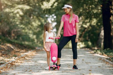 Anne ve kızı yaz parkında oynuyorlar.