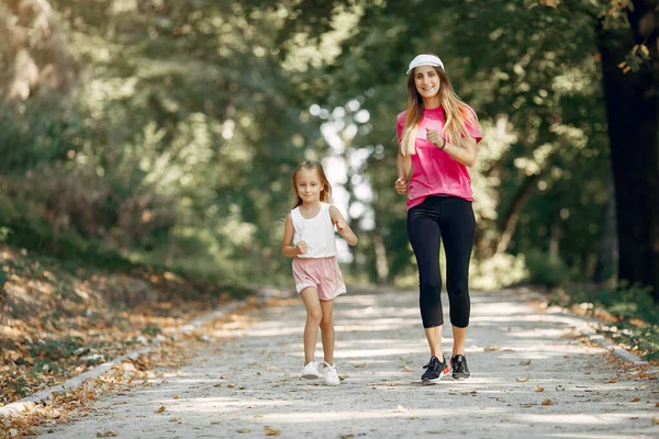 Mutter mit Tochter beim Sport im Sommerpark — Stockfoto