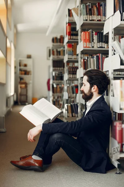 Pohledný chlap v knihovně — Stock fotografie
