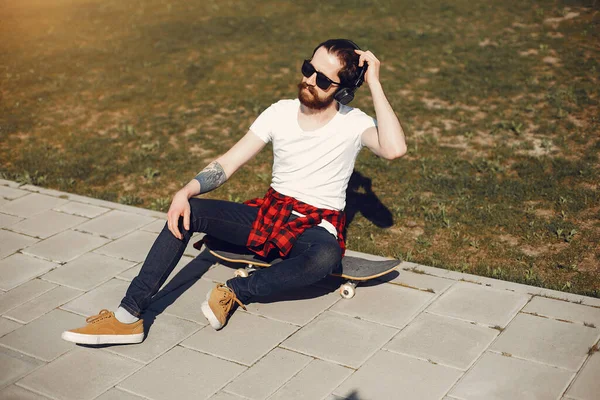 Stylischer Typ mit Schlittschuhen in einer Sommerstadt — Stockfoto