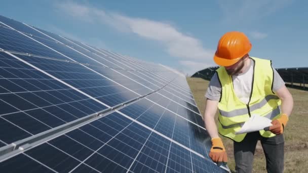 Ingegnere maschio in uniforme sta controllando la batteria solare al di fuori — Video Stock