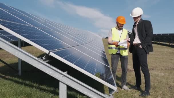 İşadamı ve işçi güneş enerjisi istasyonunda projeyi tartışıyorlar. — Stok video