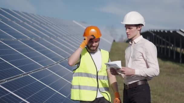 Biznesmen i pracownik są w elektrowni słonecznej omawiając projekt — Wideo stockowe