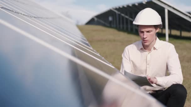 Een man controleert het zonnepaneel in de fabriek. — Stockvideo