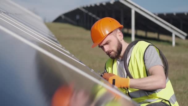 Ingegnere maschio in uniforme sta controllando la batteria solare al di fuori — Video Stock