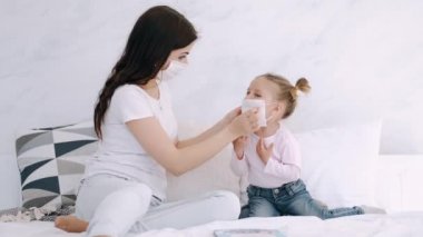 Annem kızlarının yüzüne maske takıyor.