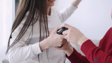 Güzel bir kız ve bir oğlan oturma odasında video oyunu oynuyorlar.