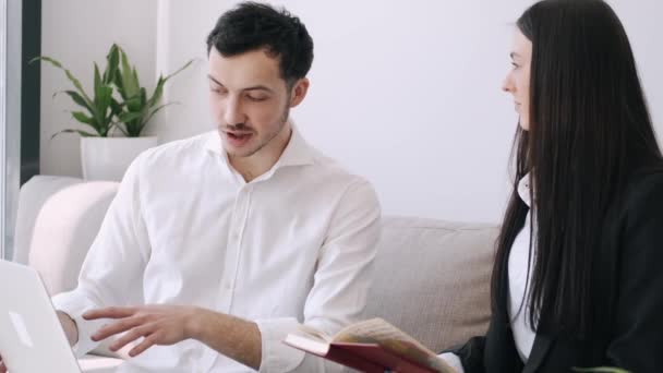 Un hombre oficial guapo y una chica guapa están leyendo algo en cuadernos — Vídeo de stock