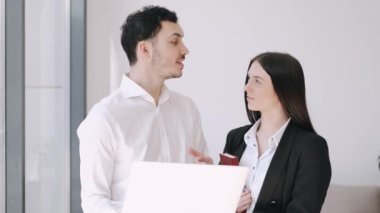Yakışıklı bir adam ve resmi tarzda bir kız konuşuyor.