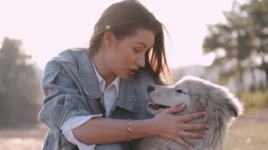 Güzel kız tarlada sevimli tüylü bir köpekle yürüyor.