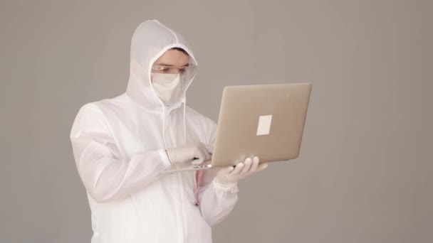 Wissenschaftler in Vollschutzausrüstung forscht am Laptop — Stockvideo