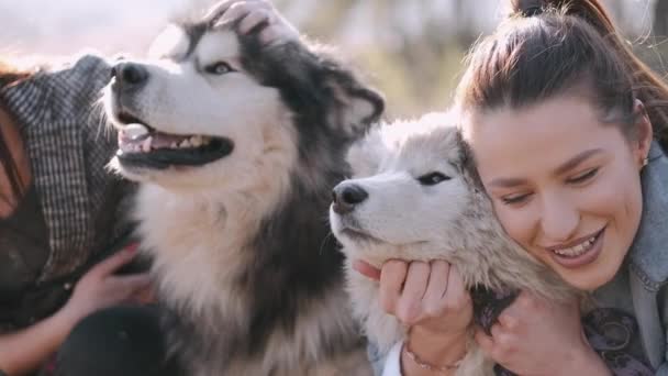 Genç güzel kadınlar gülümsüyor ve sevimli köpekleriyle sarılıyorlar. — Stok video