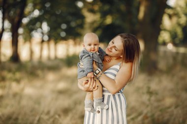 Anne ve küçük oğlu sonbahar tarlasında oynuyorlar.