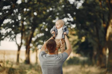 Sonbahar tarlasında oynayan sevimli bir aile.