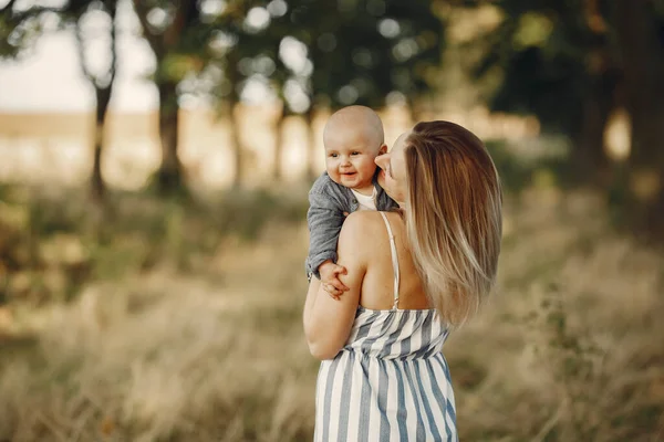 Mutter mit kleinem Sohn spielt auf einem Feld im Herbst — Stockfoto