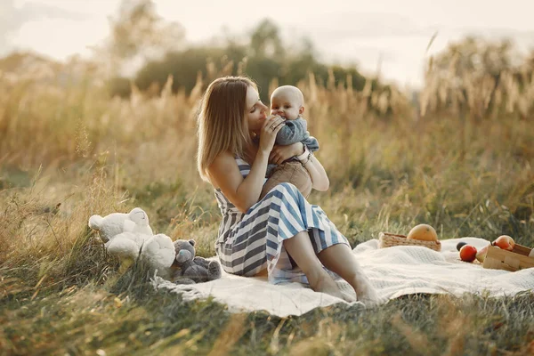 Madre con hijo pequeño sentado en un campo de otoño —  Fotos de Stock