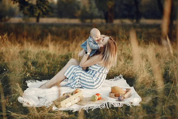 Anya kisfiúval ül az őszi mezőn. — Stock Fotó