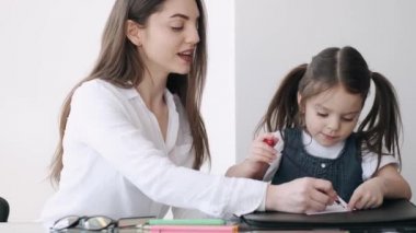 Anne ve kızı birlikte resim çiziyorlar.