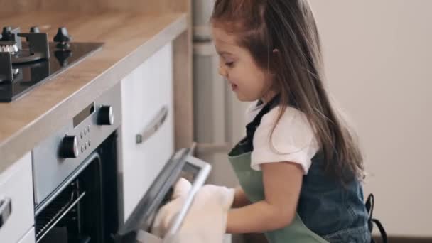 Дівчина закриває плиту рушником на кухні — стокове відео