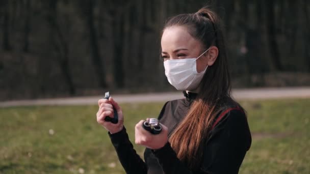Mujer atlética en una máscara protectora está haciendo ejercicio con apretones de manos — Vídeos de Stock