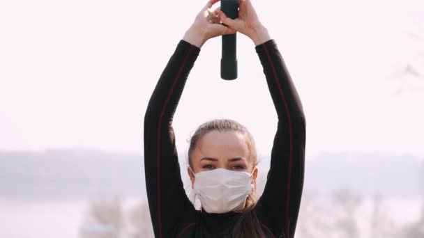 Αθλητική γυναίκα σε μια προστατευτική μάσκα κάνει άσκηση με αλτήρες — Αρχείο Βίντεο