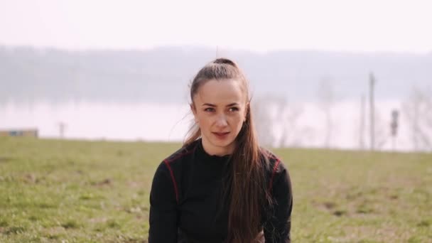 Mulher atlética está fazendo exercício com halteres perto do lago — Vídeo de Stock