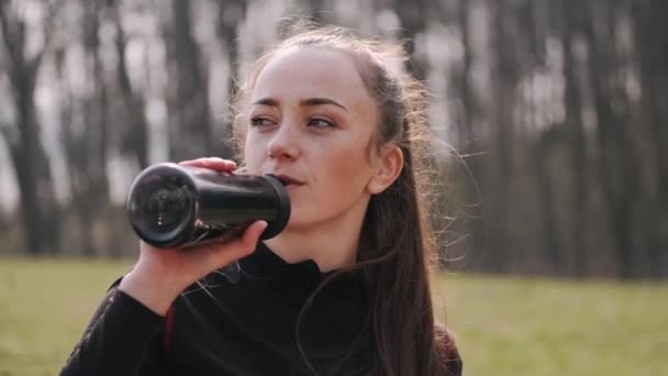 Atletická žena pije vodu z fitness láhve — Stock video