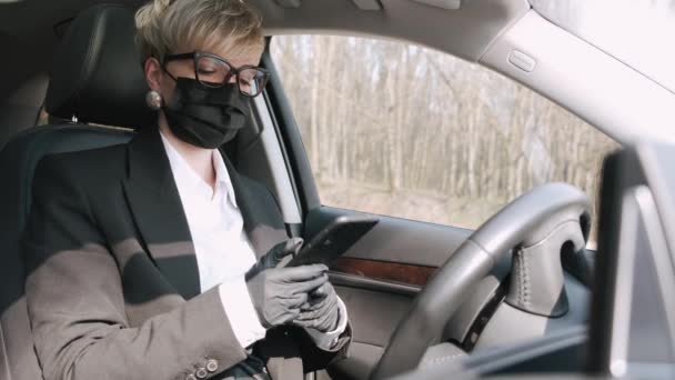 A businesswoman in glasses is making a call in a car — Stock Video