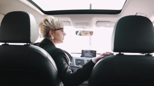 A businesswoman is driving a car and backing up — Stock Video