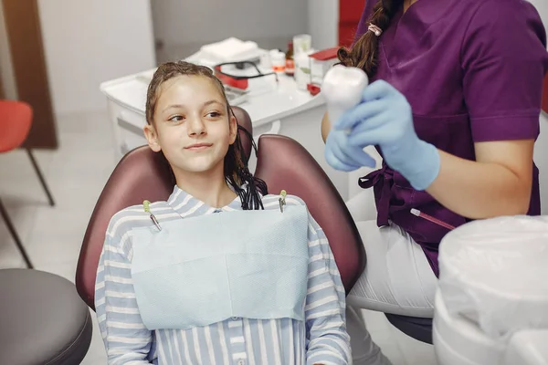 Mooi klein meisje zitten in de tandartsen kantoor — Stockfoto