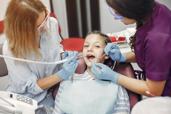 Mooi klein meisje zitten in de tandartsen kantoor — Stockfoto