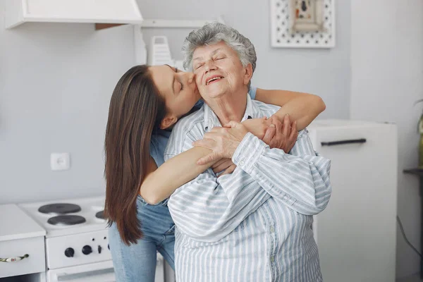 Стара жінка на кухні з молодою онучкою — стокове фото